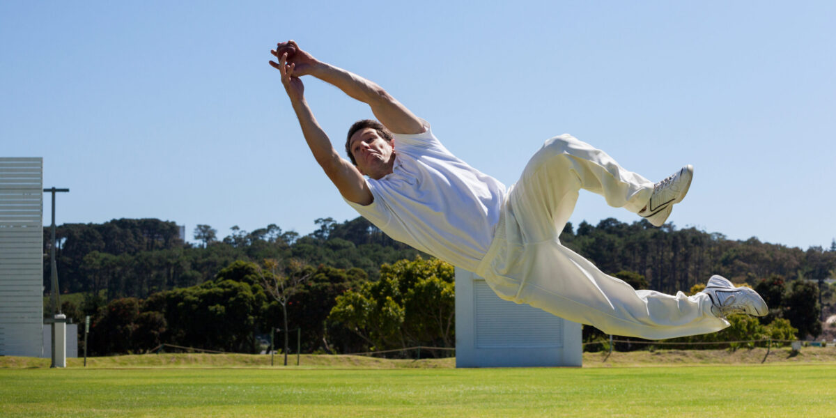 Full,Length,Of,Player,Diving,To,Catch,Ball,Against,Blue